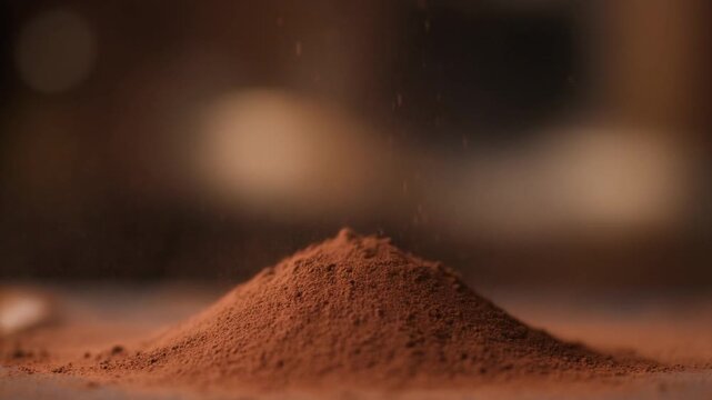 A close-up view of a small pile of powder on a flat surface with a blurred background