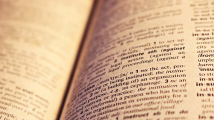 Fototapeta premium Blurry image dictionary page with out of focus. Photo for learning, studying, knowledge, reading, hobby, school, student, teacher, university, English language, book, literature.