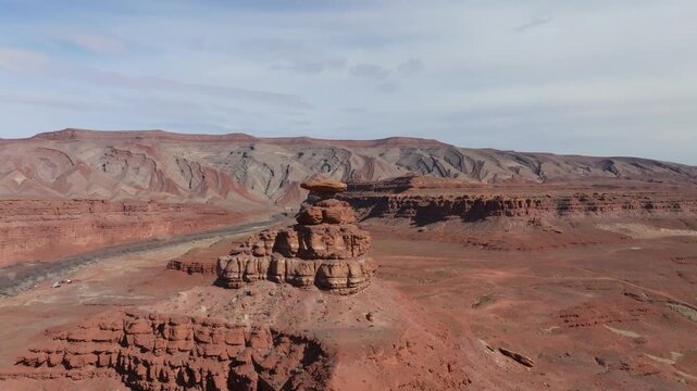 Aerial view of the desert landscape in Mexican Hat, Utah. Cinematic drone shot of red rock formations and vast horizons in the American Southwest wilderness.
