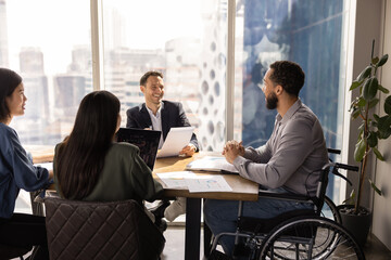 Happy African American project manager with disability offering business idea for brainstorming on group meeting. Diverse team of analysts discussing marketing strategy for project