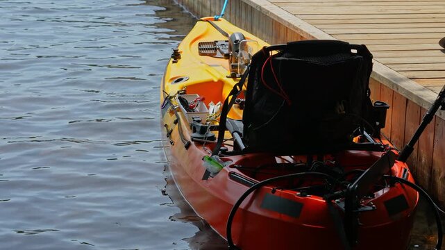 Fully rigger kayak like drone watercraft with electric trolling underwater motors is mooring and tied to boat pier near cottage boat house. Recreational watercraft, works with remote, kayaking lake.