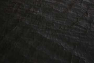 Fototapeta premium Dark rippling water moves under dim light.