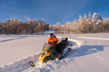 Athlete on a snowmobile moving in the winter forest in the mountains of the Southern Urals
