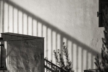 A view of the staircase and the shadow of the railing on the plastered wall