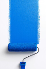 Obraz premium Top view of a paint roller applying a vertical stripe of blue paint on a white surface