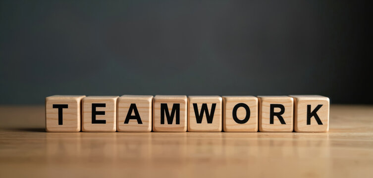 Wooden blocks spell TEAMWORK on a table. Concept about collaboration and business success. Idea for teamwork theme, project success, group effort.