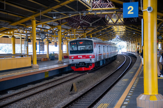 Jakarta, Indonesia - May 15, 2024 : A KRL Commuterline train arriving at the curved platform of Gondangdia elevated station