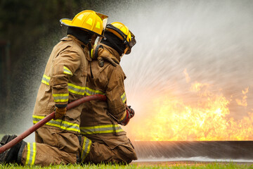 Naklejka premium Firefighters extinguishing burning car during emergency response