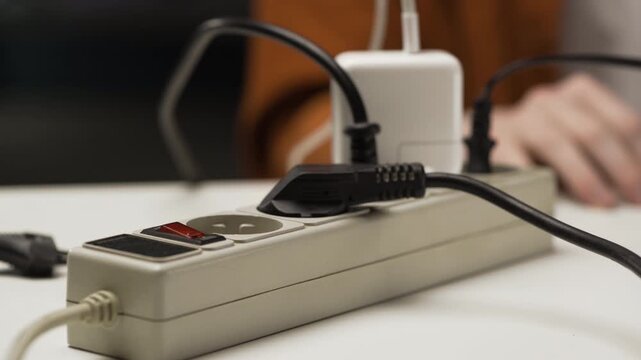 Energy efficiency. Man using electrical plug in outlet socket at home.