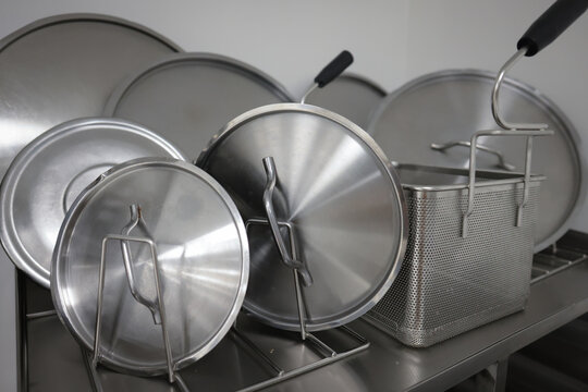Details with stainless steel kitchen pots, pans and utensils in a professional canteen or hospital kitchen