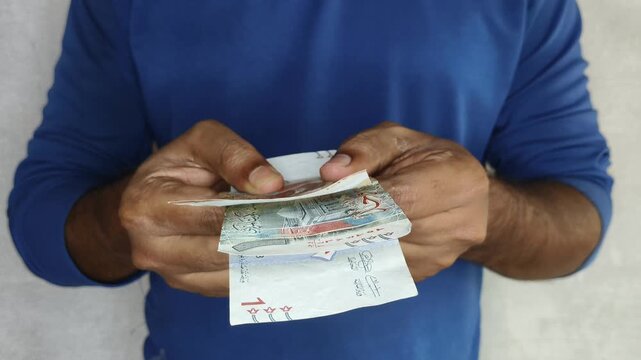 Kuwaiti dinar (kwd) kuwait currency note money closeup. adult person hand offering banknote towards camera. Sharing, charity, donation, support, compassion, humanity and community help concept.