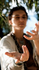 A beautiful brunette dressed in boho style meditates and dances in the forest. A magical ritual takes place against a green forest backdrop.