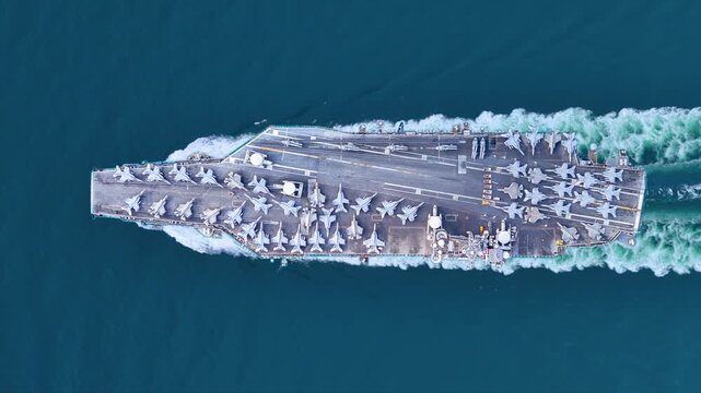 Nuclear ship warship Military navy ship carrier full loading fighter jet aircraft and Helicopters sailing in the ocean. Military warship deck loaded with fighter jets Naval defense power army force