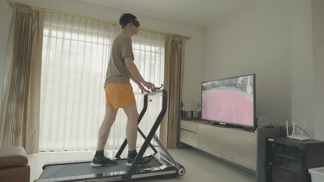 A person exercising on a treadmill indoors while watching a fitness program on TV. A motivating environment to stay active and healthy.