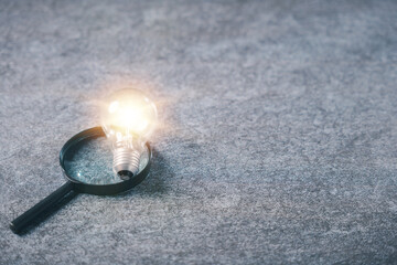 Obraz premium College career ideas shine through glowing lightbulb placed over magnifying glass for college innovation, search for creative insight leads to college career path success
