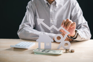 Home property investment shows growth, hand holds rising chart, house, percentage symbol, money, coins, calculator indicate increasing real estate mortgage loan rate