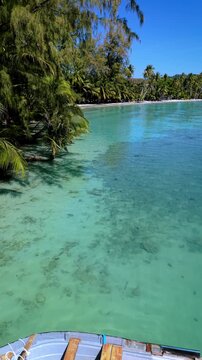 Discover the beauty of Koh Kood, Thailand as a small boat floats peacefully in shimmering turquoise waters surrounded by lush greenery.