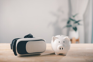 Piggy bank vr save future metaverse virtual digital technology reality, finance investment tools for people shown on wooden table surface inside bright indoor office room
