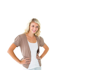 Fototapeta premium Adult female posing hands on hips, smiling, wearing layered clothing on white backdrop, copy space