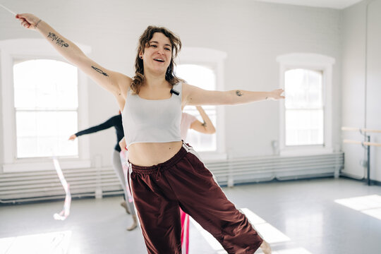 Woman exercising rhythmic gymnastics with ribbon in studio