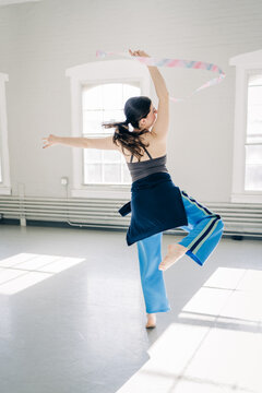 Gymnast performing rhythmic gymnastics ribbon routine in studio