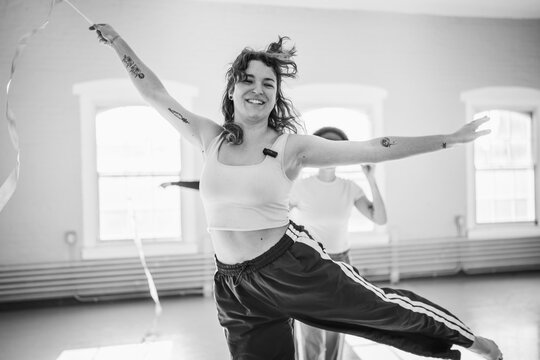 Joyful woman dancing with ribbon in studio