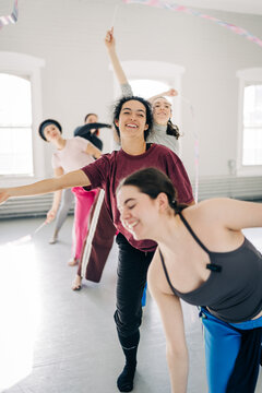 Diverse women training rhythmic gymnastics with ribbons indoors