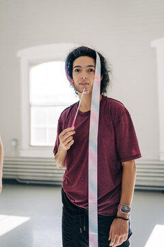 Young person holding and balancing gymnastics ribbon