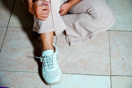 view of a woman's feet wearing white chunky sneakers with a thick sole design and patterned laces and a background for text space. close up of a woman's feet wearing sneakers and athletic shoes.