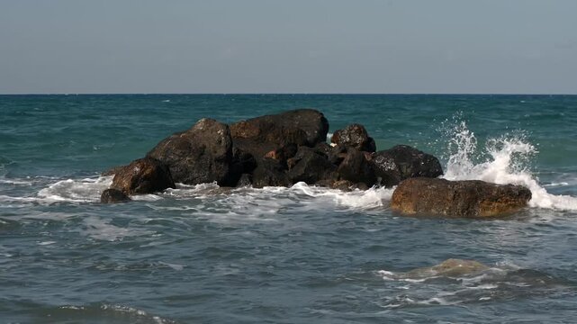 Stunning aerial footage of massive limestone and volcanic rock formations rising from the crystal clear turquoise Mediterranean Sea just meters from the shoreline near Gaziveren village, Northern Cypr