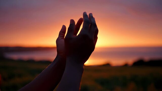 Hands Reaching for Sunset - A person's hands are reaching up toward the setting sun, conveying a sense of hope and gratitude in the warm golden hour light.
