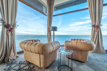 Luxury Hotel Lounge, Two Beige Leather Chesterfield Armchairs Facing Large Windows with Panoramic Ocean View