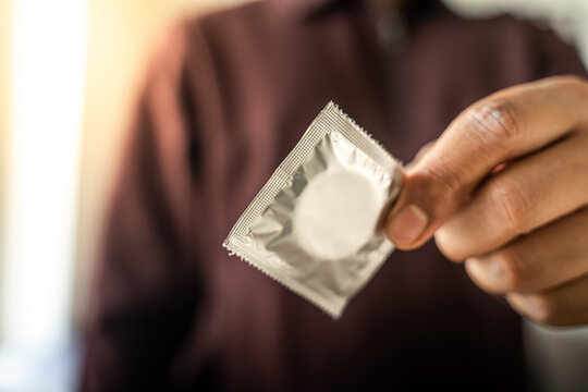 Condom packet in human hand.