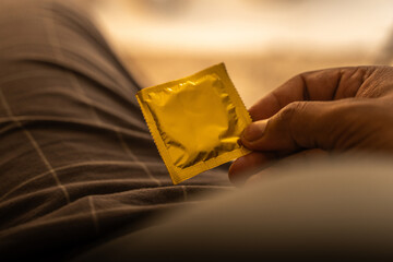 Condom packet in human hand.