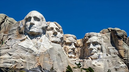 Mount Rushmore Presidents carved into granite mountain under blue sky