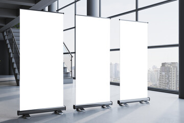 Blank vertical roll up banner mockups standing in a modern interior hallway with large windows and city view in background. 3D Rendering