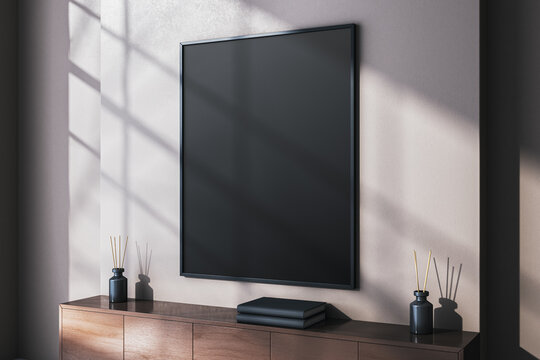 Vertical black blank poster frame on wall in modern interior room with sunlight and shadow creating artistic display background concept. 3D Rendering