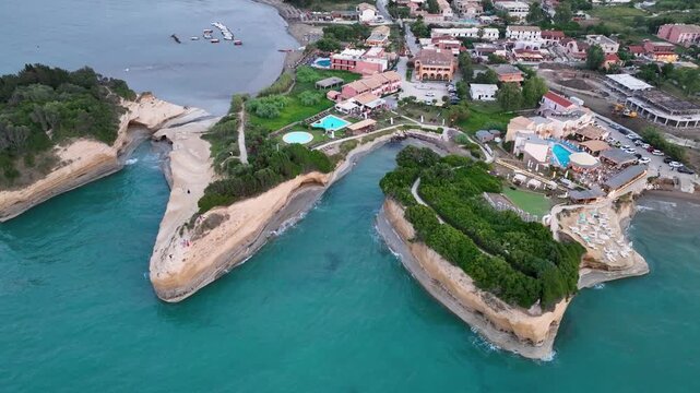High-angle aerial drone revealing the famous Canal d'Amour, the tourist resorts, and the village of Sidari, Corfu, Greece