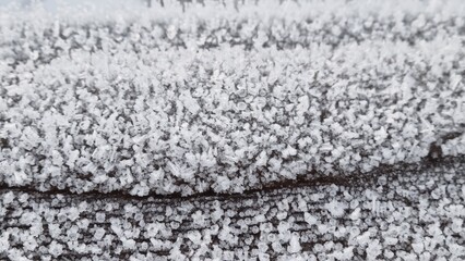 Frost covers a wooden surface during the early morning hours in winter