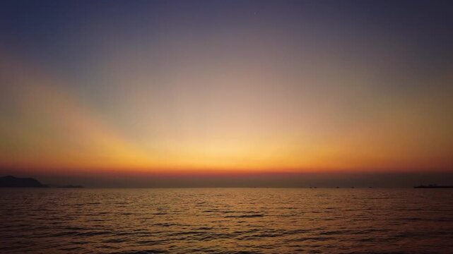 Beautiful sunset over calm sea water. Serene nature scene with dramatic sky gradient, 4k
