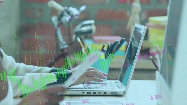 Man turning report page woman typing on laptop activating financial graphs for cross-reference