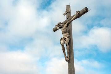 The wooden cross representing Jesus with a sky backdrop.