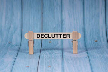 Fototapeta premium Declutter symbol. Wooden stick clamped by Clothespins, vivid blue wooden backdrop. Business and Declutter concept with copy space
