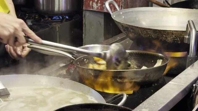 Large wok with deep frying food, street kitchen atmosphere, traditional cooking method and dynamic culinary scene.