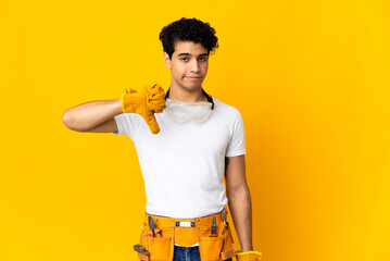 Venezuelan electrician man isolated on yellow background showing thumb down with negative expression