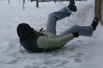 Winter Slip and Risk of Fall Accidents in Winter - a woman slips on an ice-covered road is a common winter hazard, leading to potential injuries