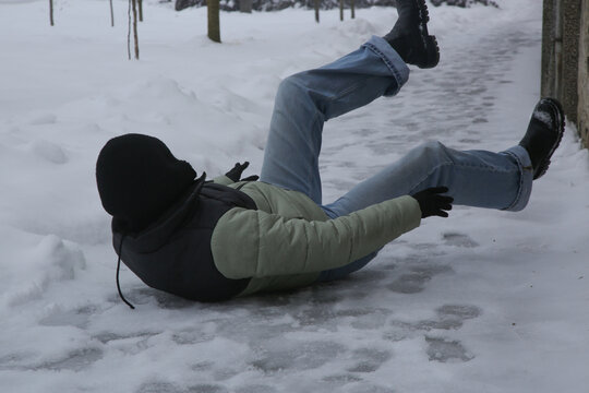 Winter Slip and Risk of Fall Accidents in Winter - a woman slips on an ice-covered road is a common winter hazard, leading to potential injuries
