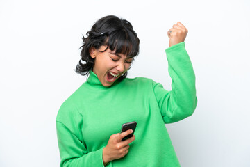 Fototapeta premium Young Argentinian woman isolated on white background with phone in victory position