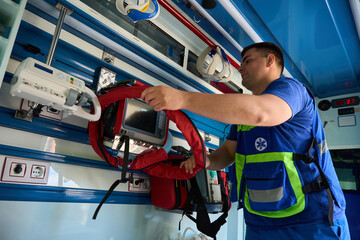 Ambulance staff organizing kit for urgent care