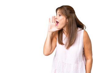Fototapeta premium Middle age woman over isolated background shouting with mouth wide open to the side